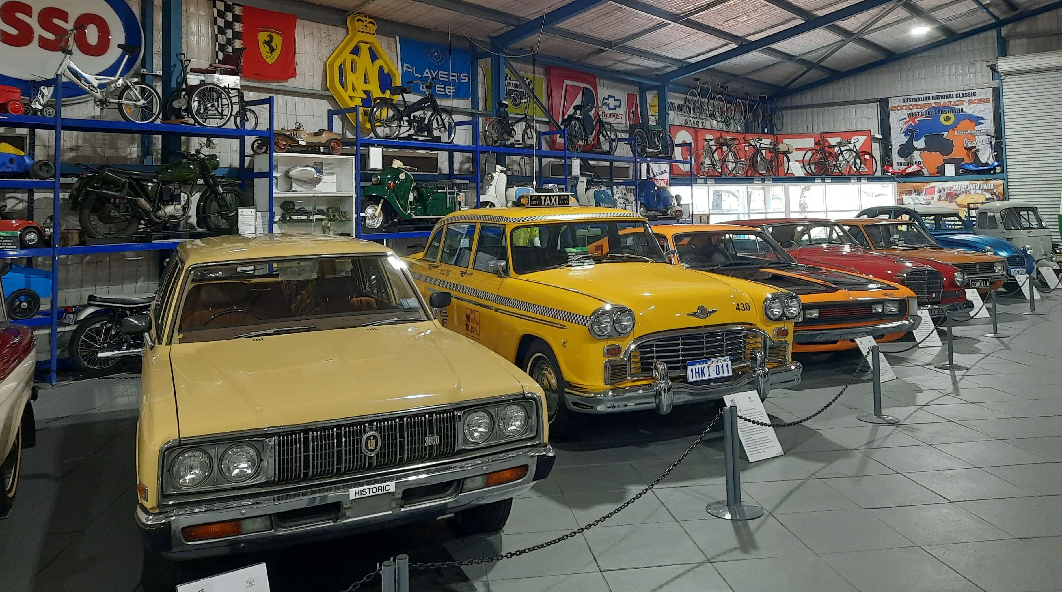Vintage cars lined up in the showroom of a motor museum.