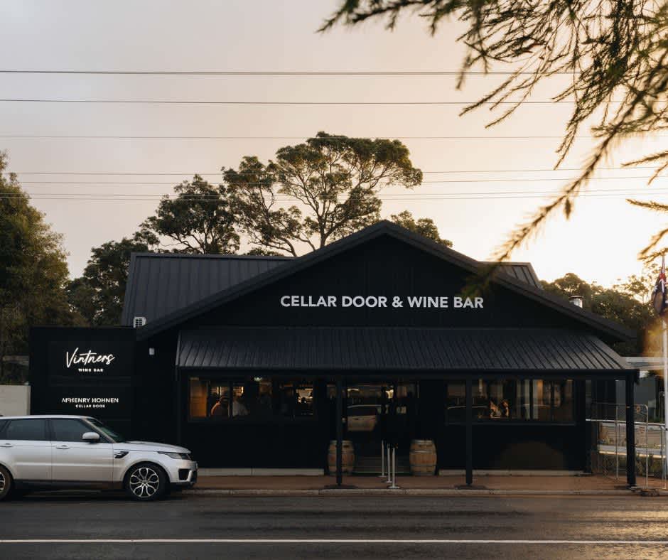 External shot at sunset of new wine bar and car parked out the front