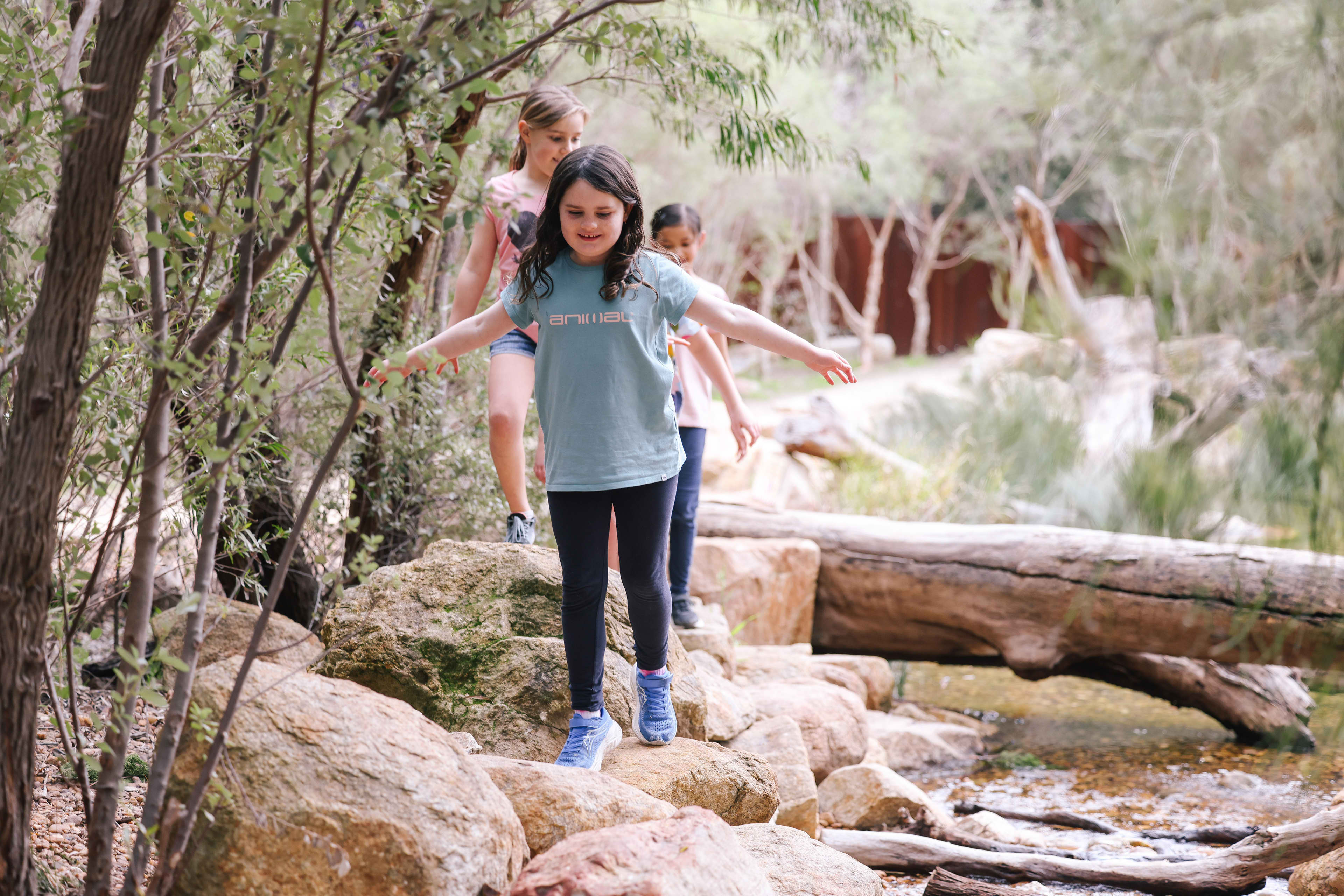 Kids running along logs and rocks in Kings Park