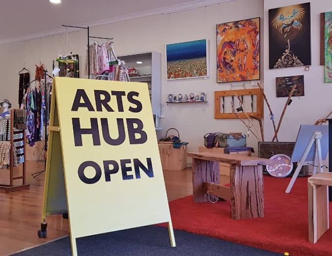 A sign that says "Arts hub open" in an art gallery