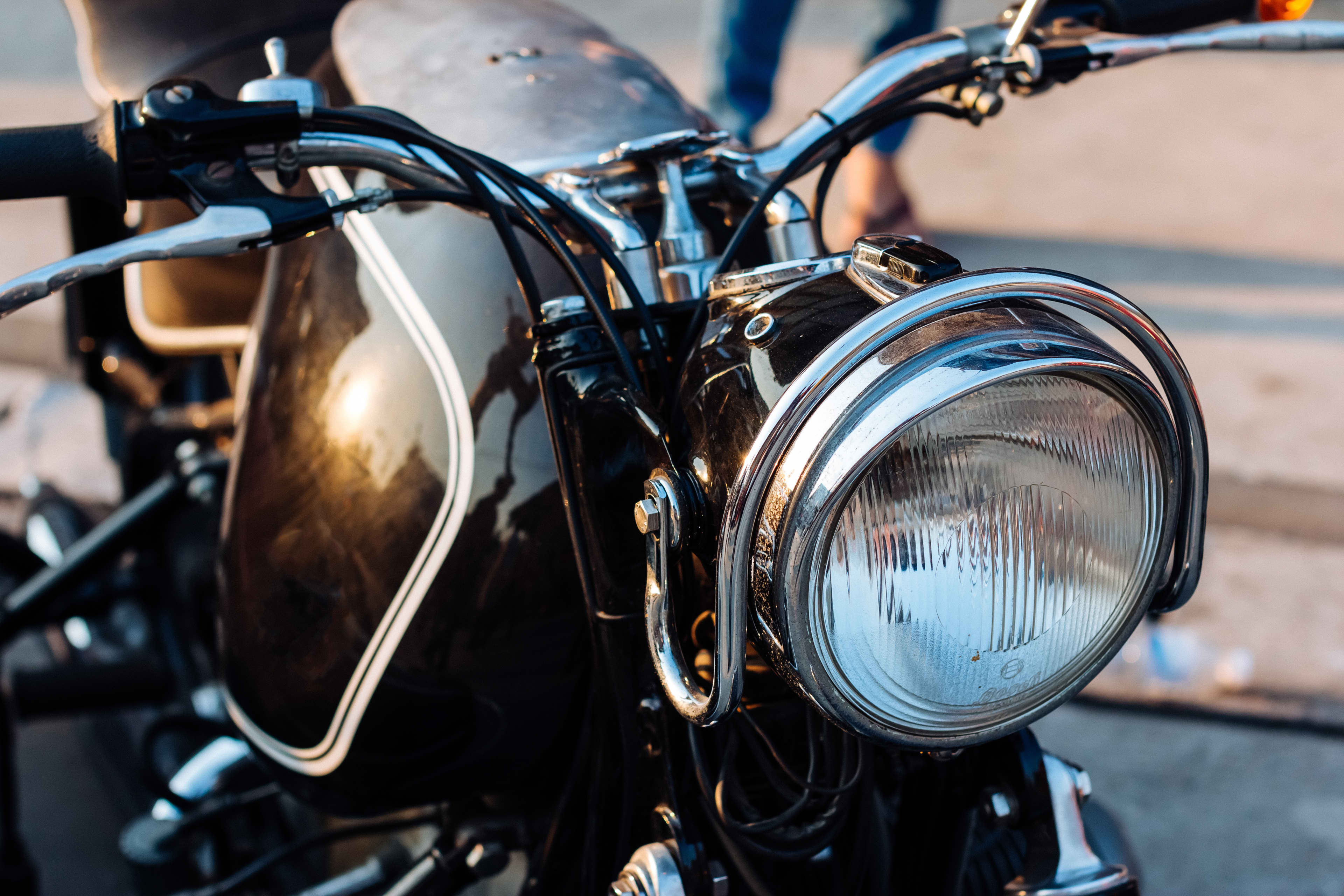 A close-up of a headlight on a classic motorcycle.