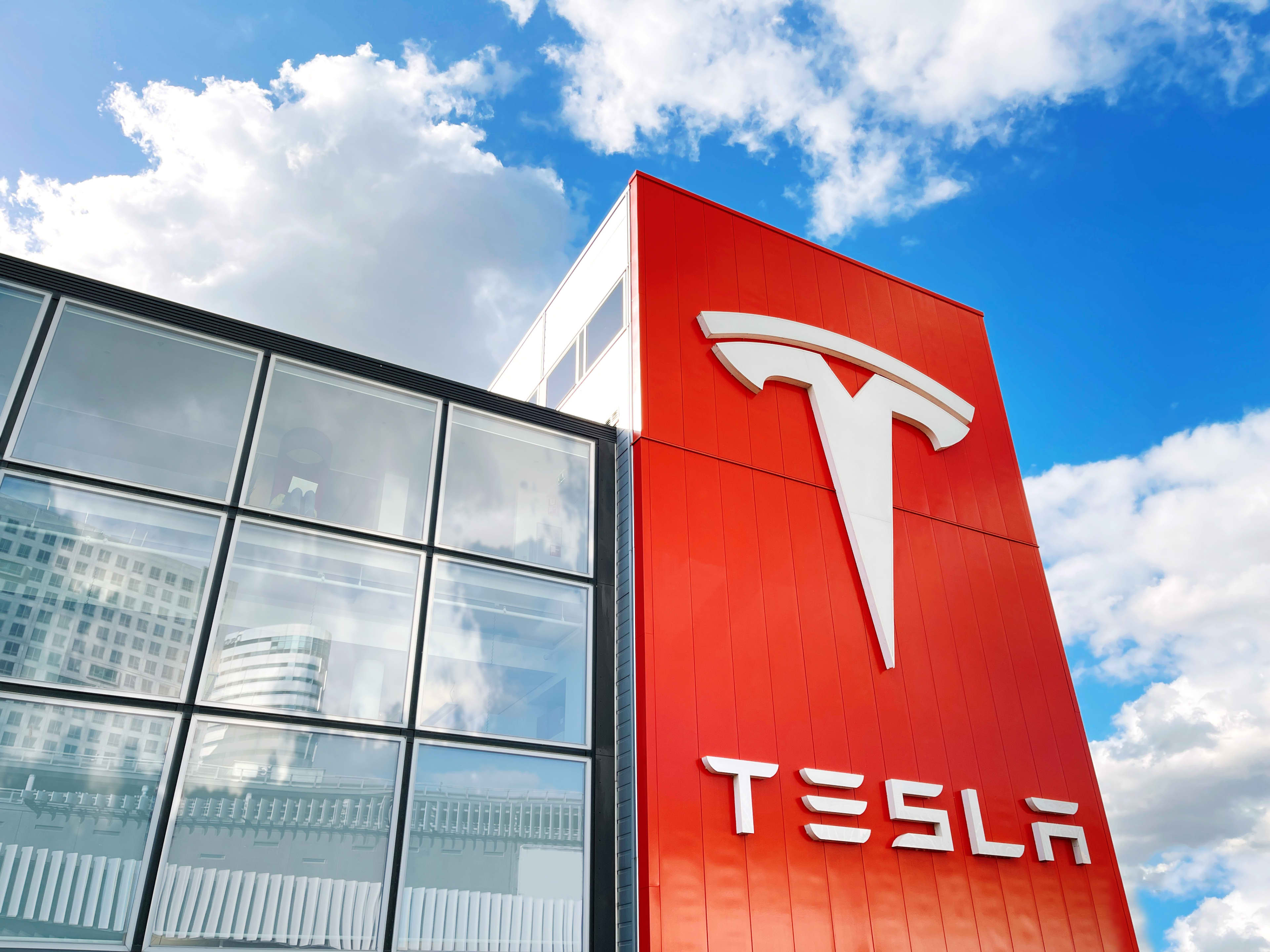 A large Tesla logo outside a Tesla dealership