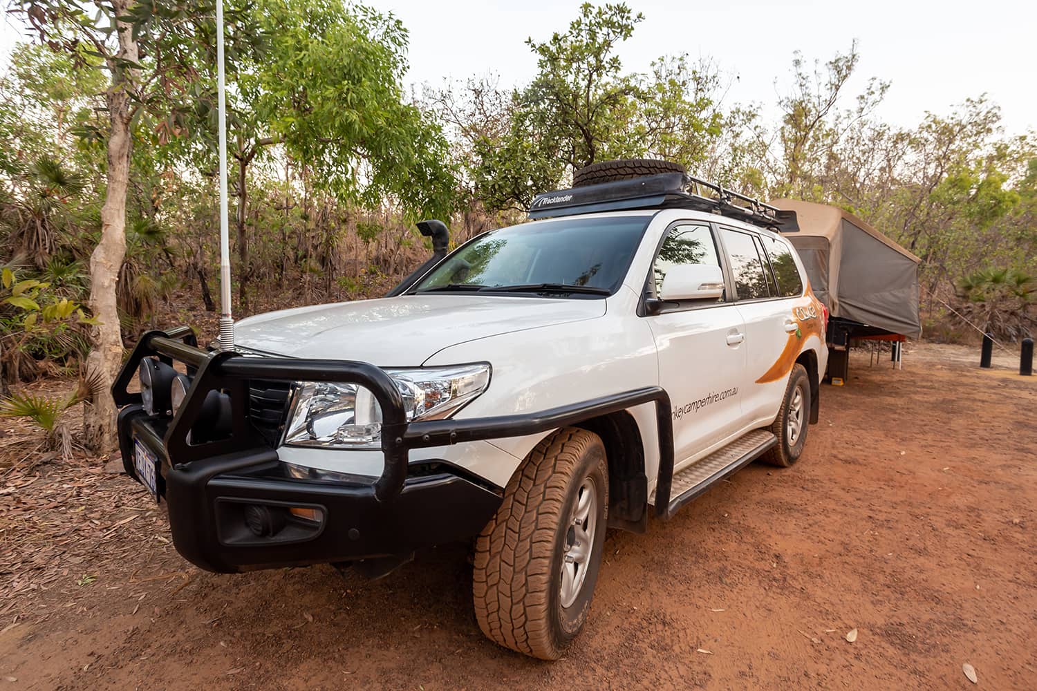 A white 4WD with a trailer attached in bushland