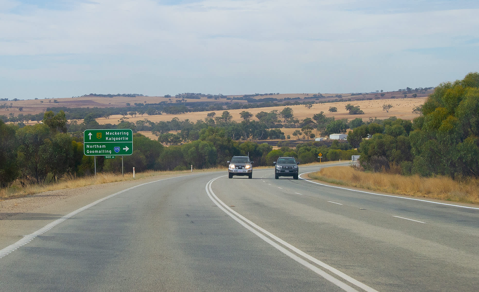 Two cars side by side on a country road in WA