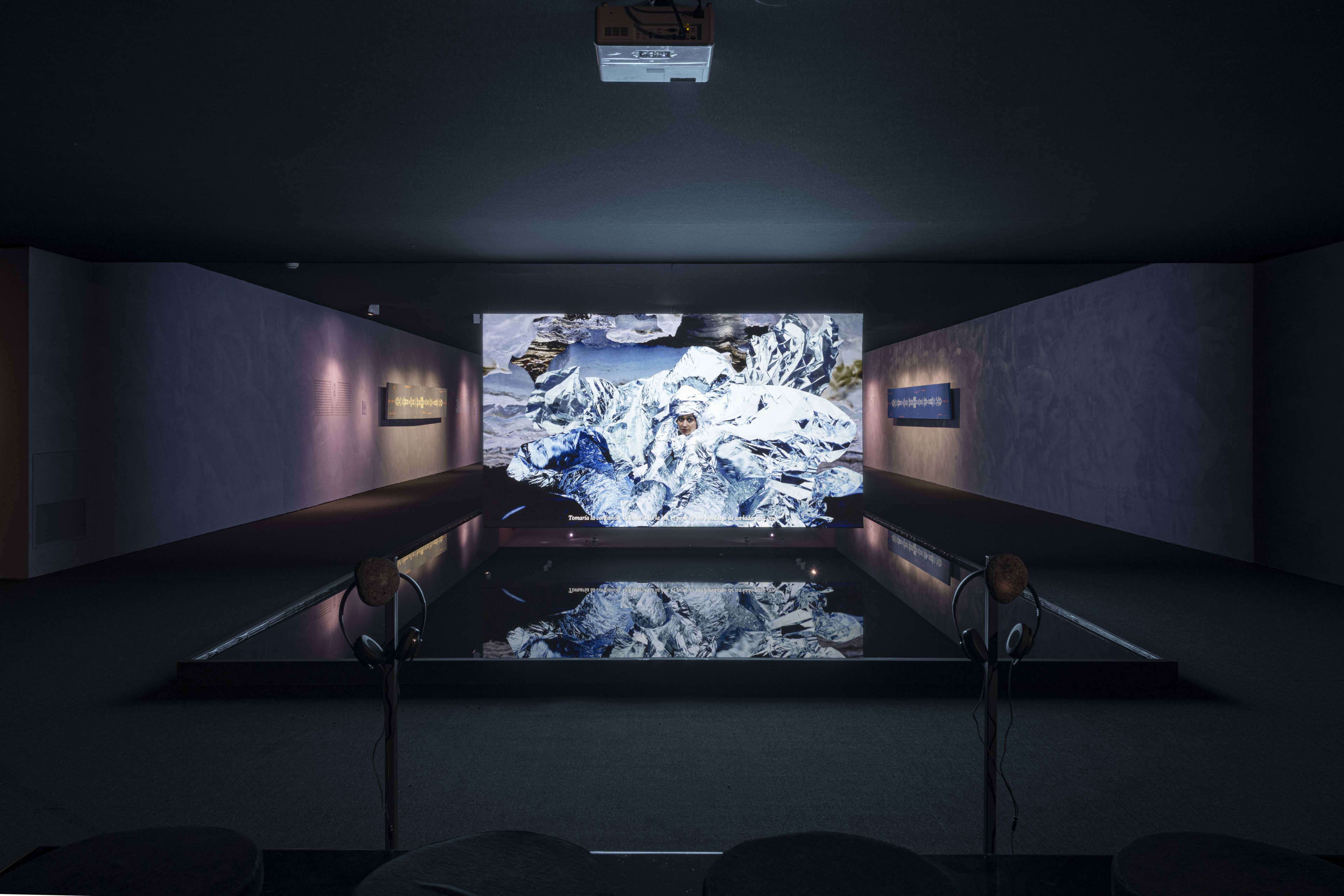 A dark room with a wall projection