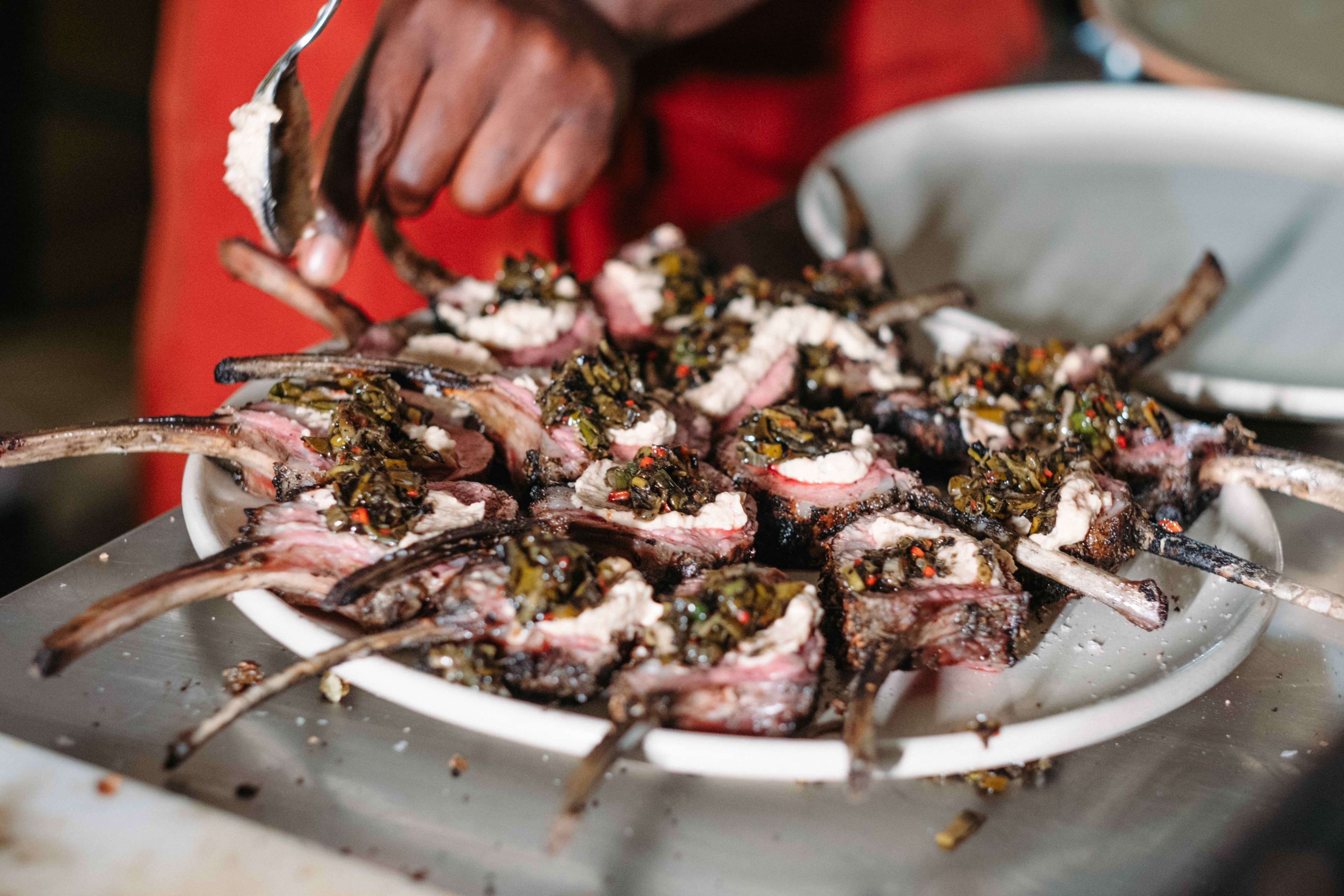 Smoked meat in flames on grill with tongs