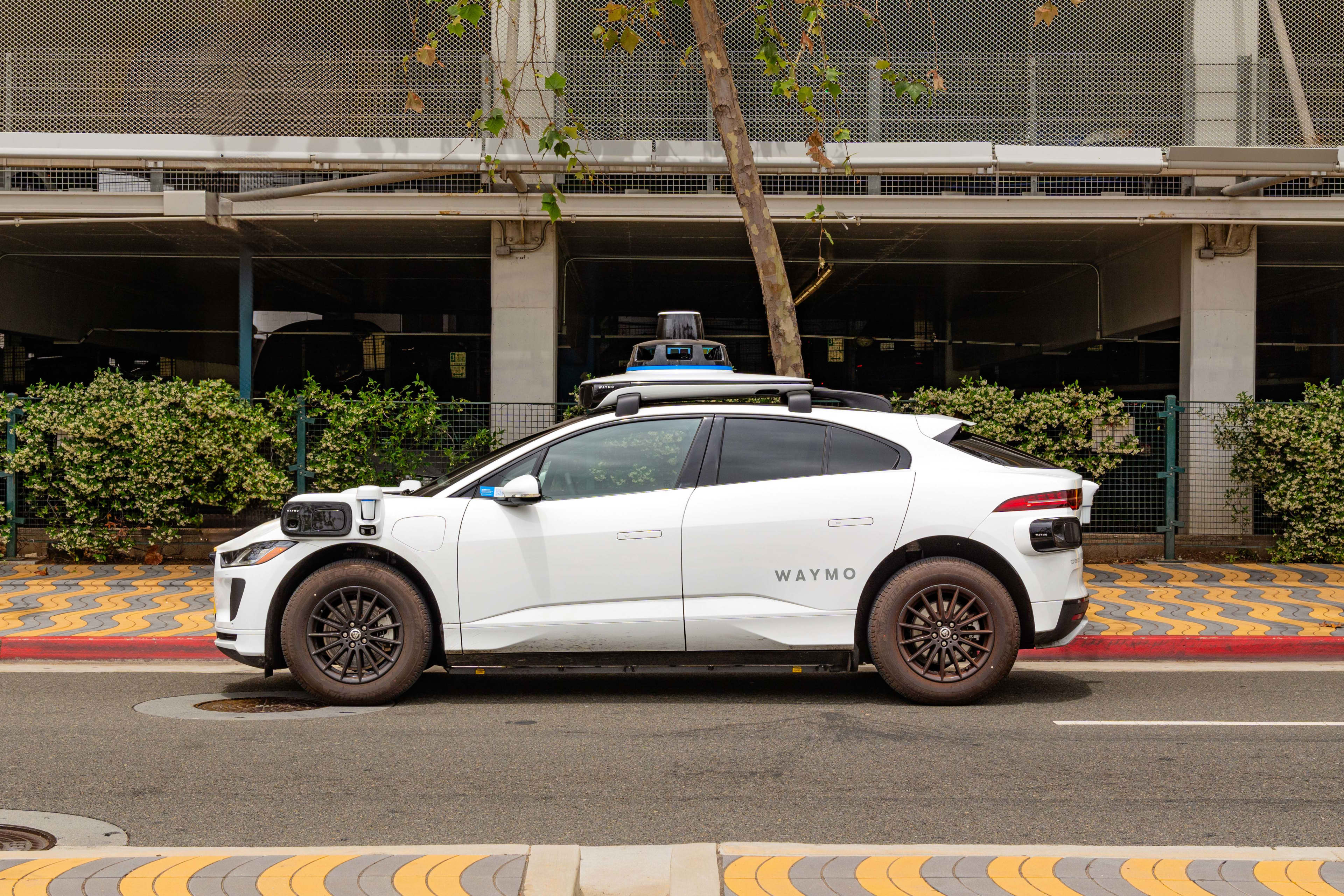 A white Waymo autonomous car parked on a city street