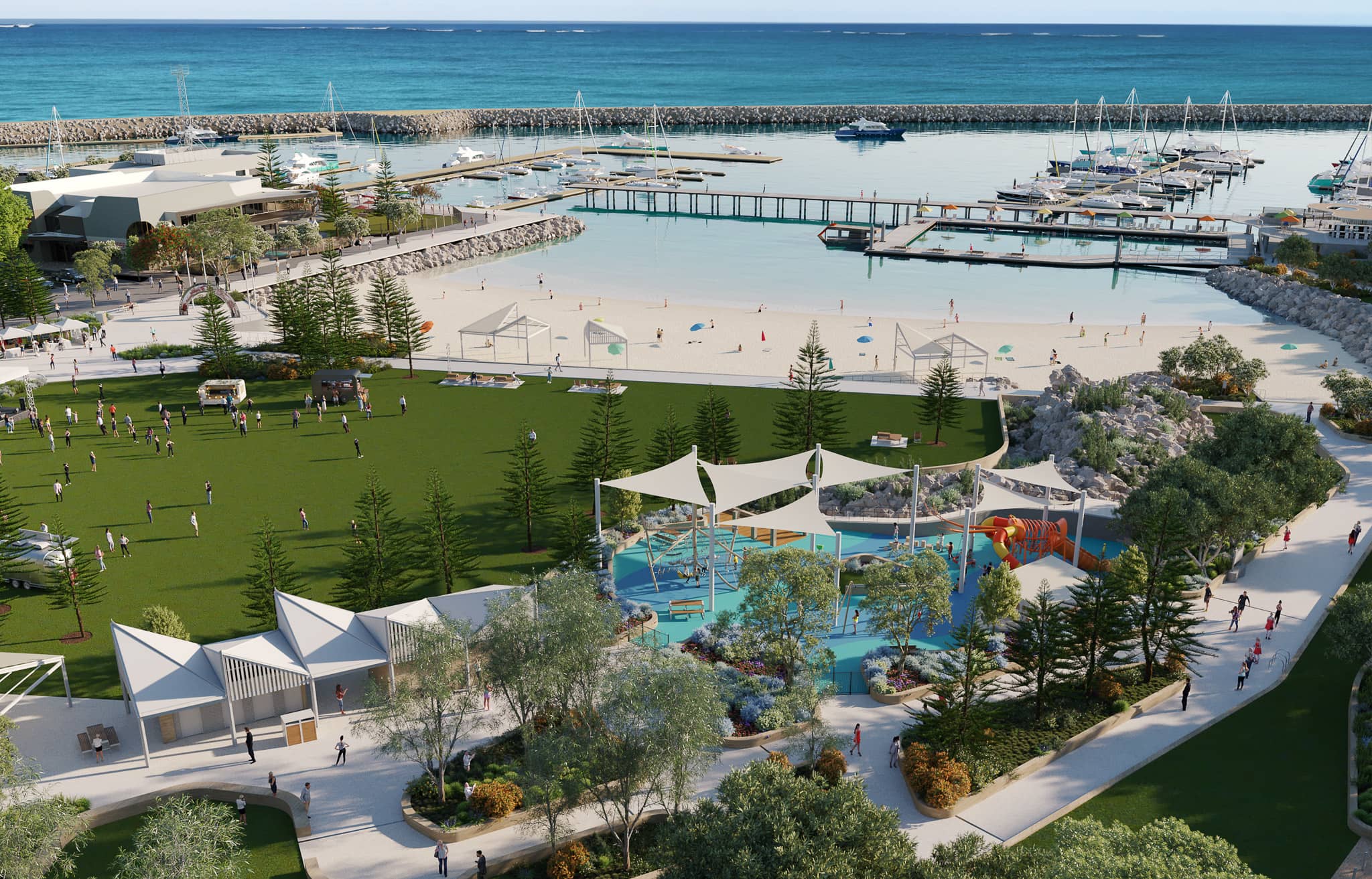 An aerial view of a marina development featuring a large grass area, sheltered beach access, and a sheltered playground.
