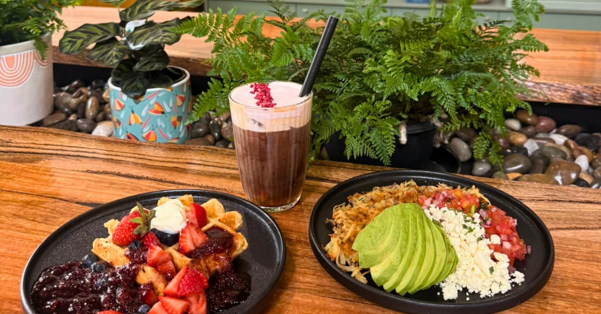 Two waffles in a cafe with a nitro cold brew on a long table.