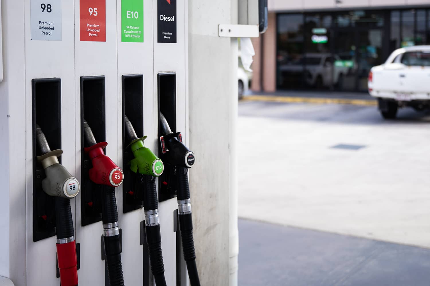 A row of fuel pump handles at a fuel station