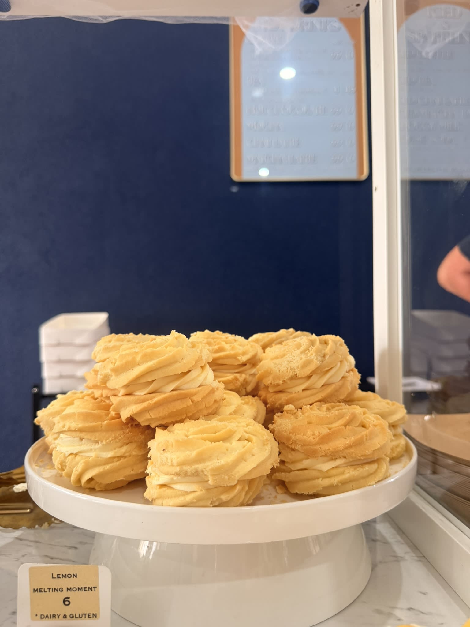 Stack of golden yellow melting moments up close in a cafe.