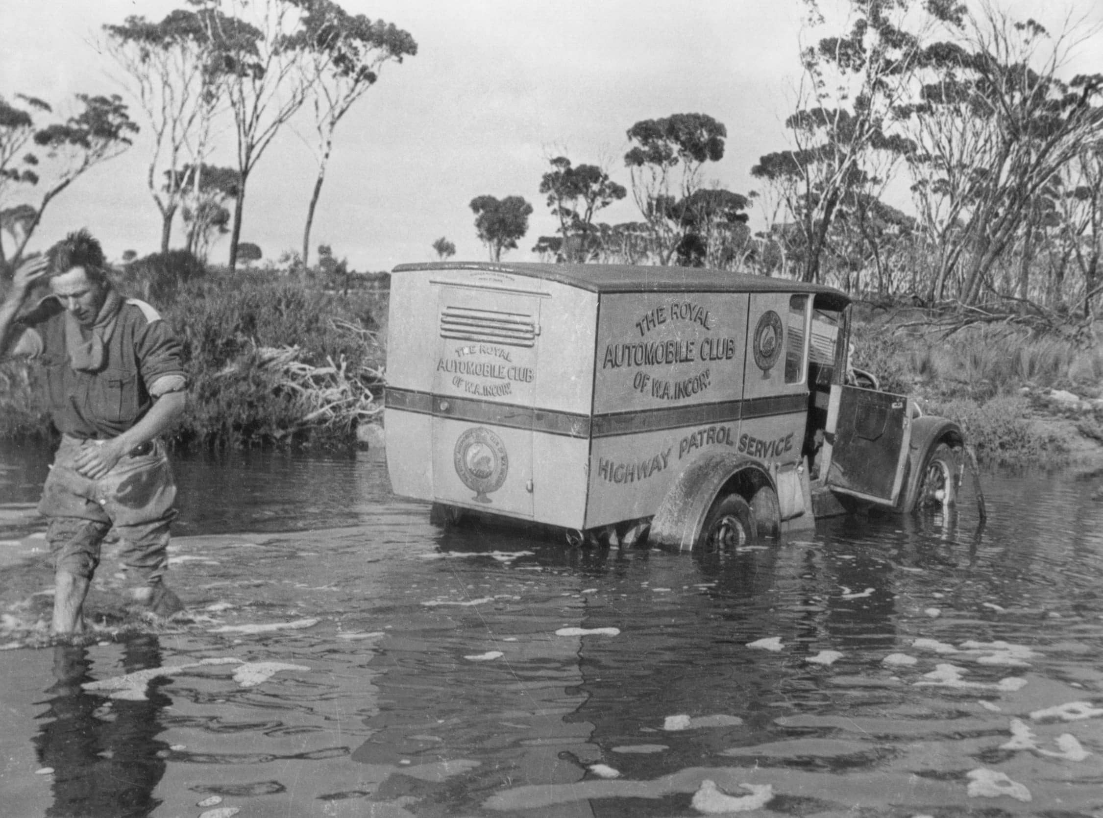 A black and white photo of an RAC Patrol wading through water