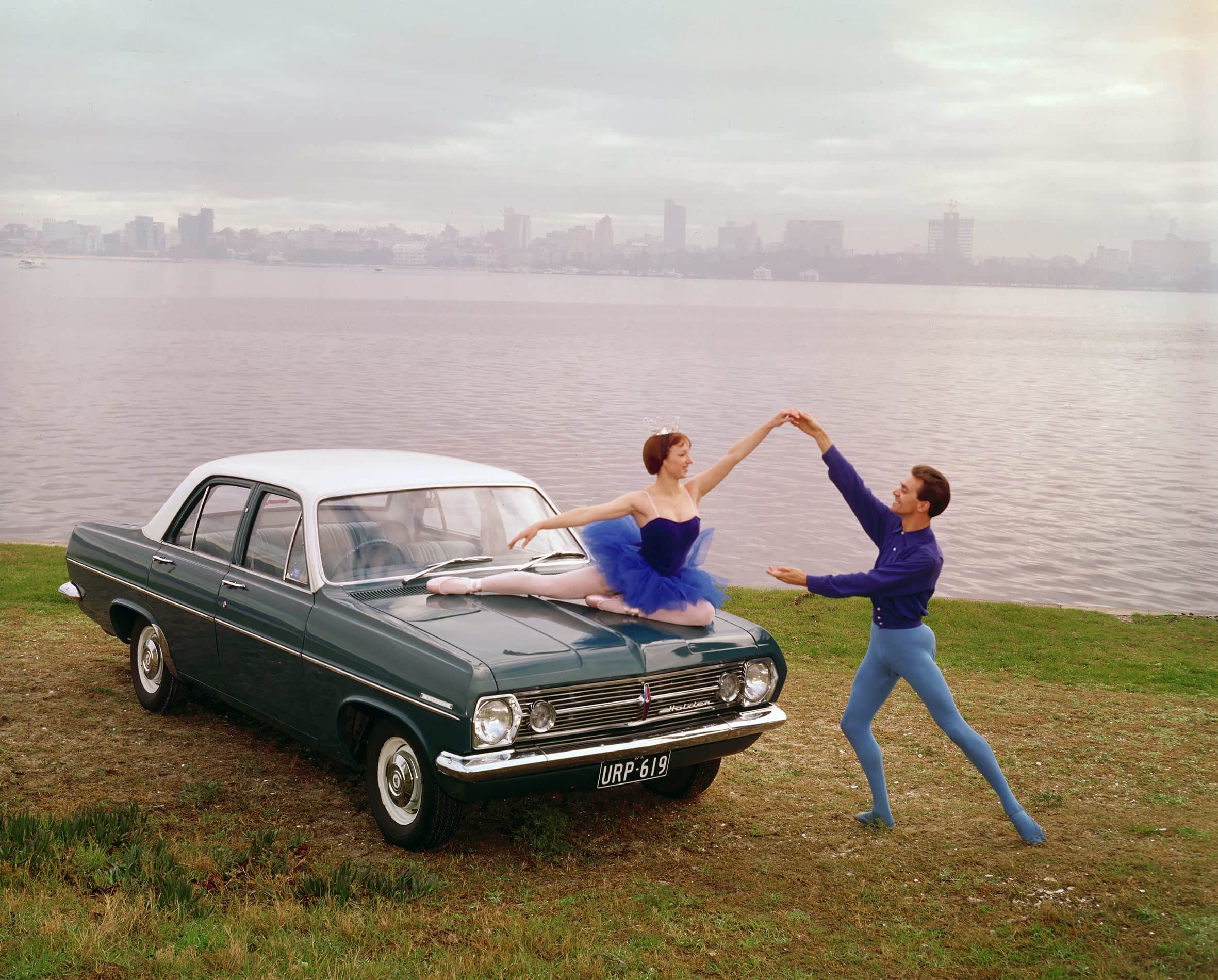 Two ballet dancers next to a 1966 Holden HR