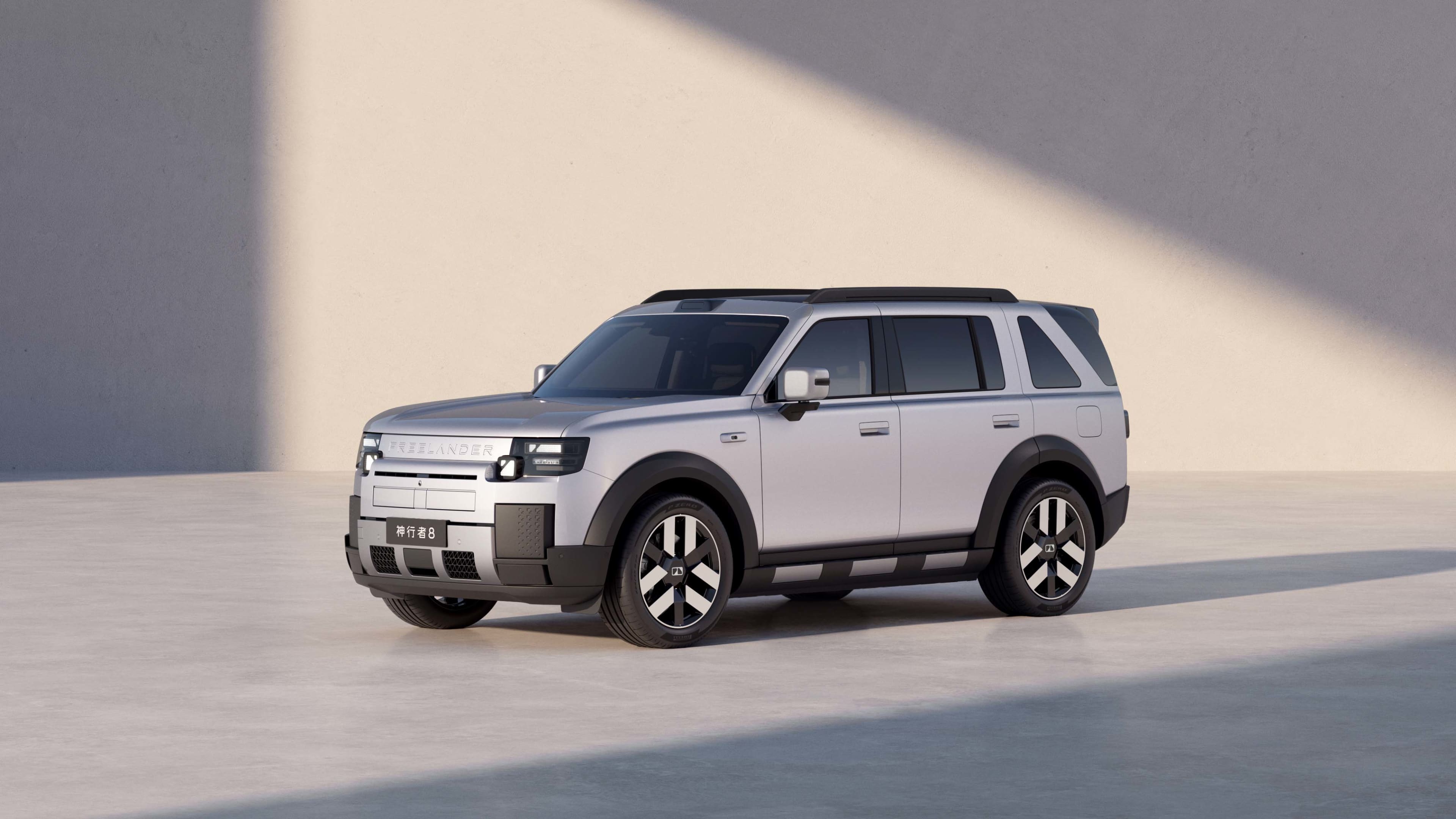 A silver Chery Freelander against a white wall