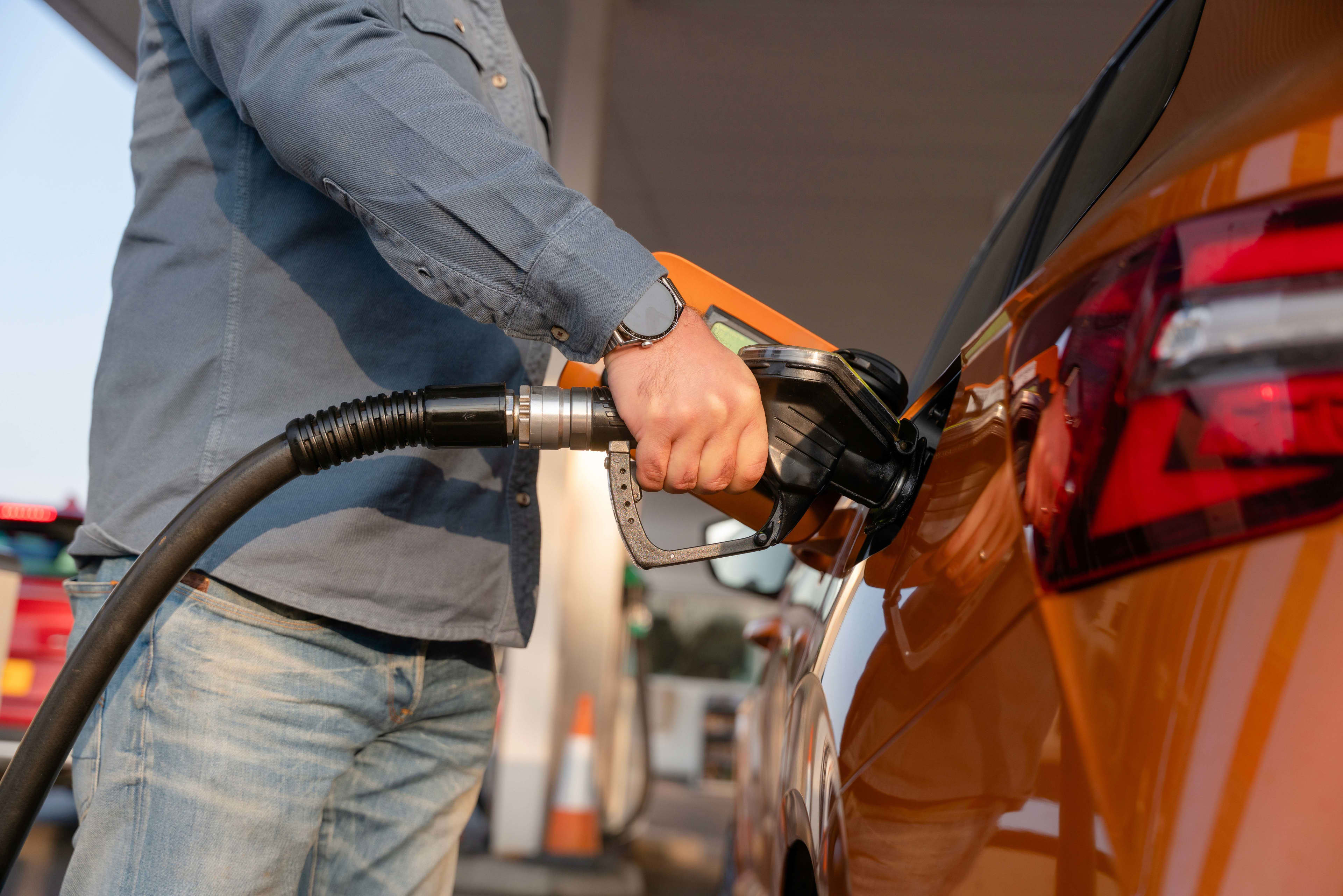 A person filling up a car with fuel