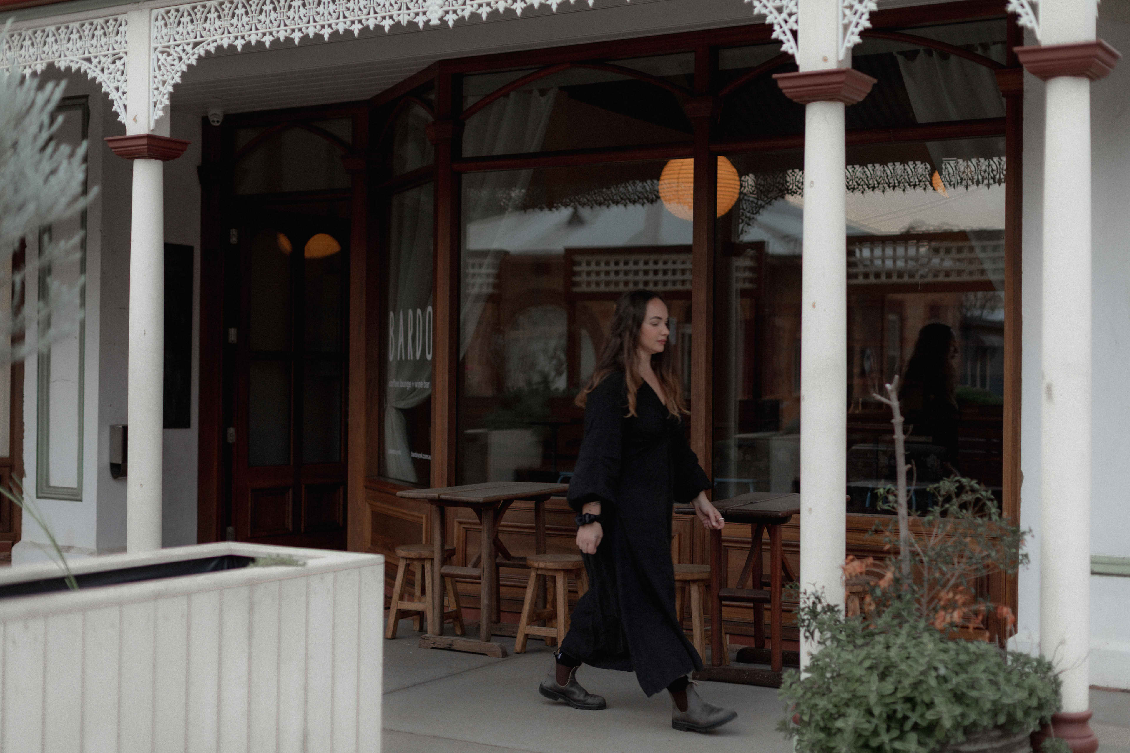 Woman walking past Bardo coffee shopfront on main street.