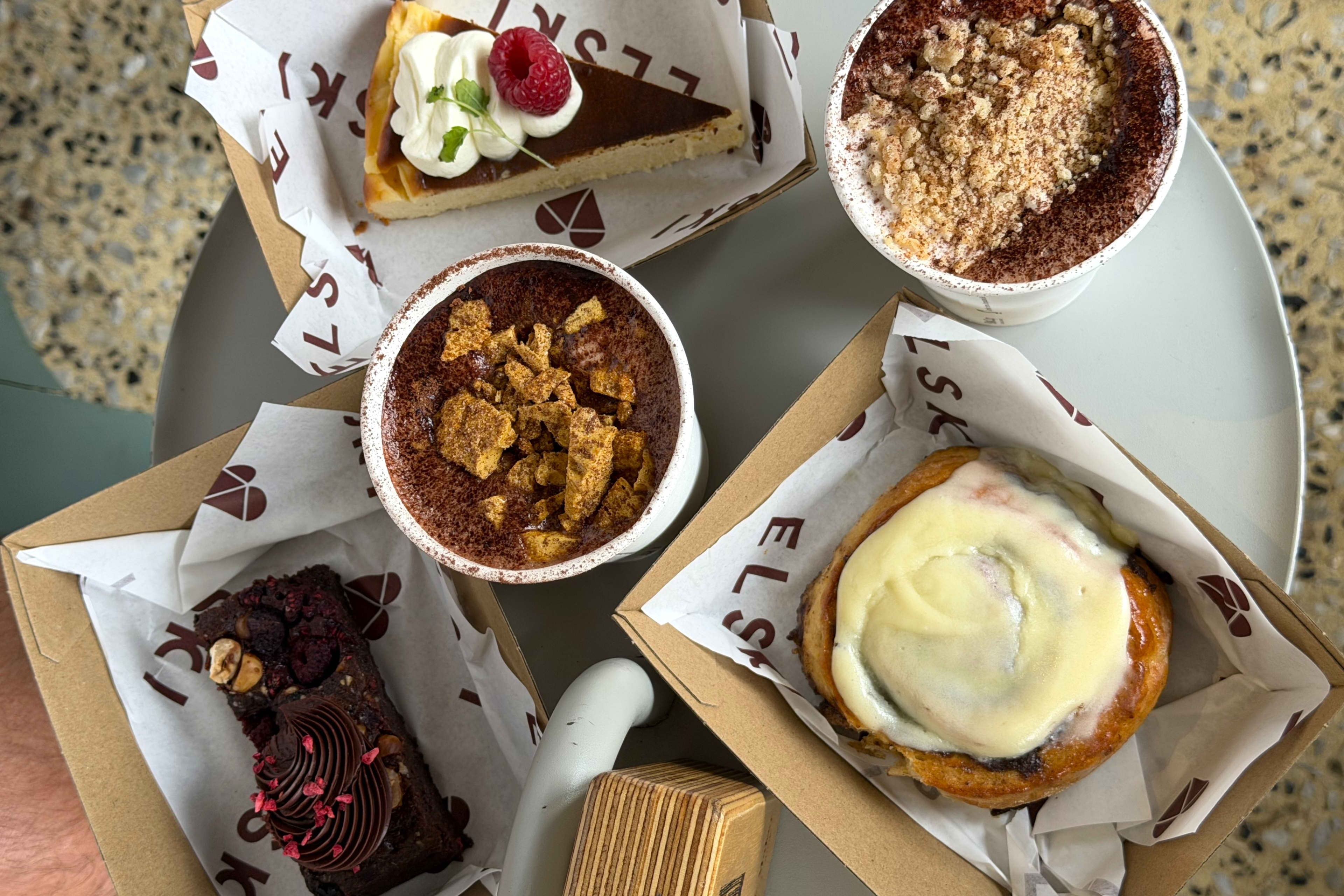 An overhead shot of an assortment of desserts arranged on a round white table.