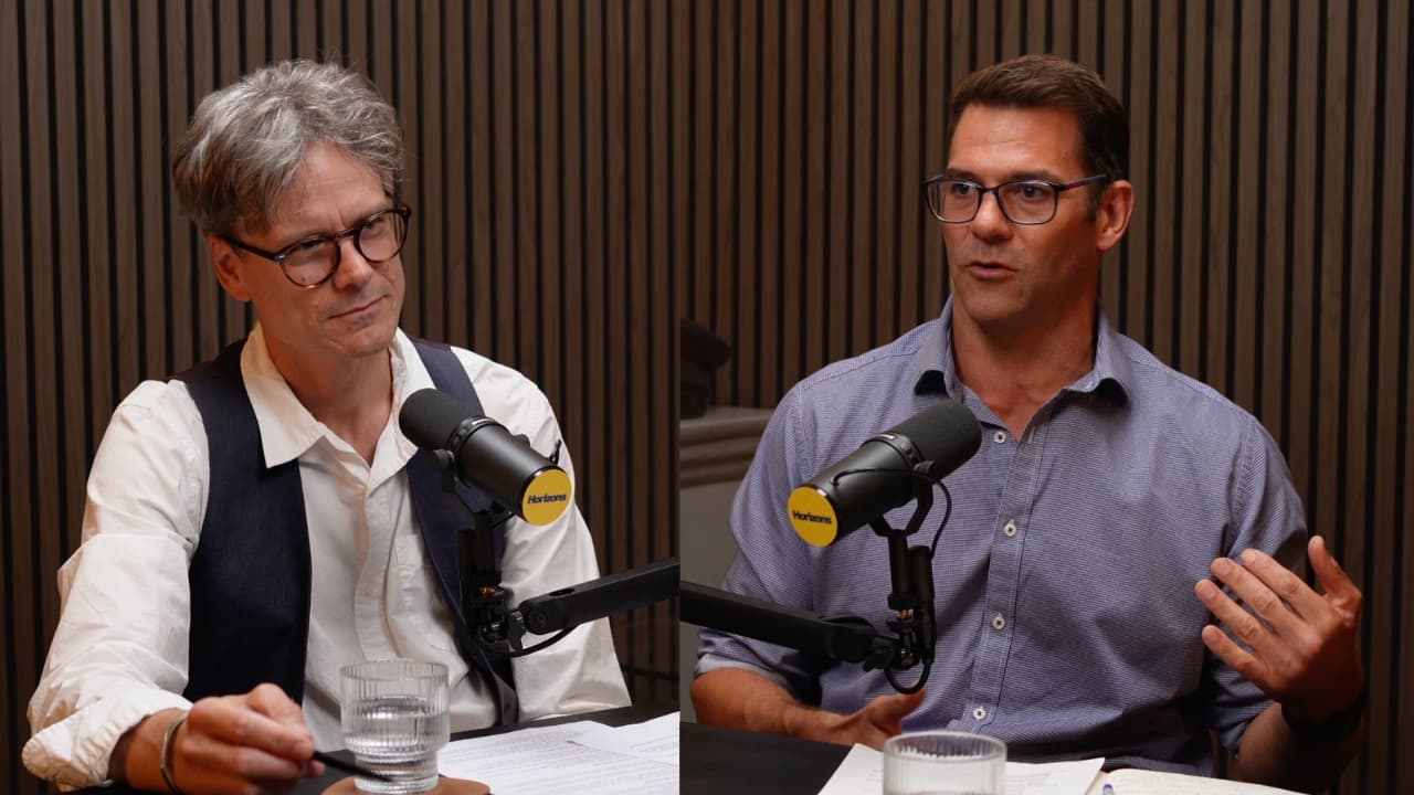 Two people in a podcast studio having a discussion