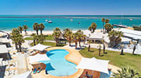 View of the Monkey Mia Dolphin Resort showing the beachfront swimming pool overlooking the ocean.